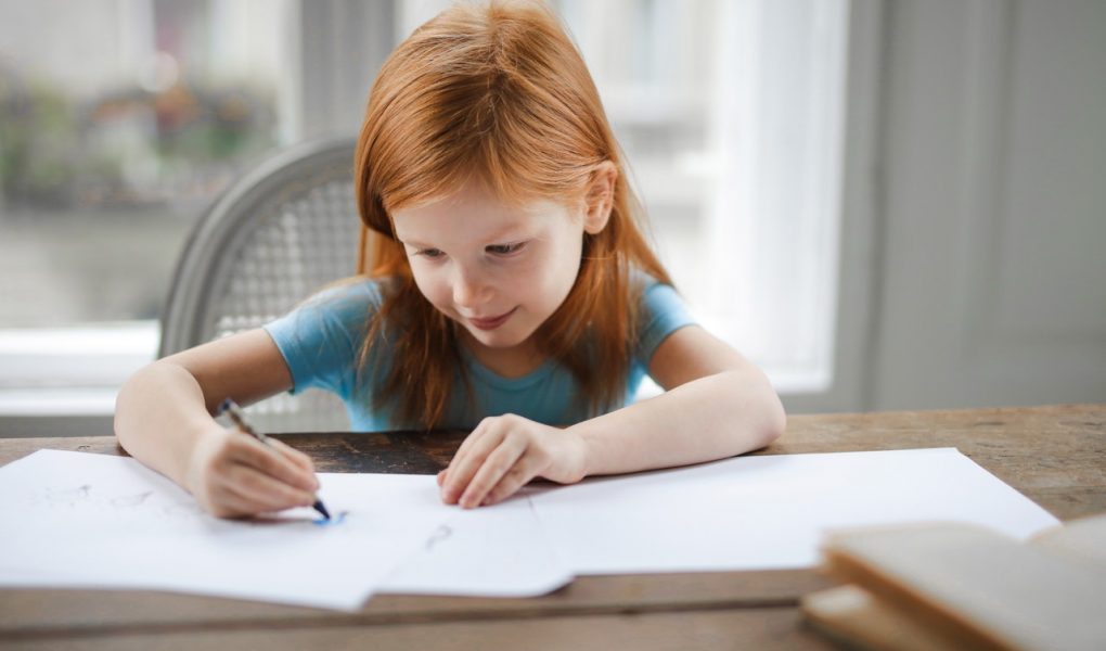 Petite fille dessinant sur son bureau
